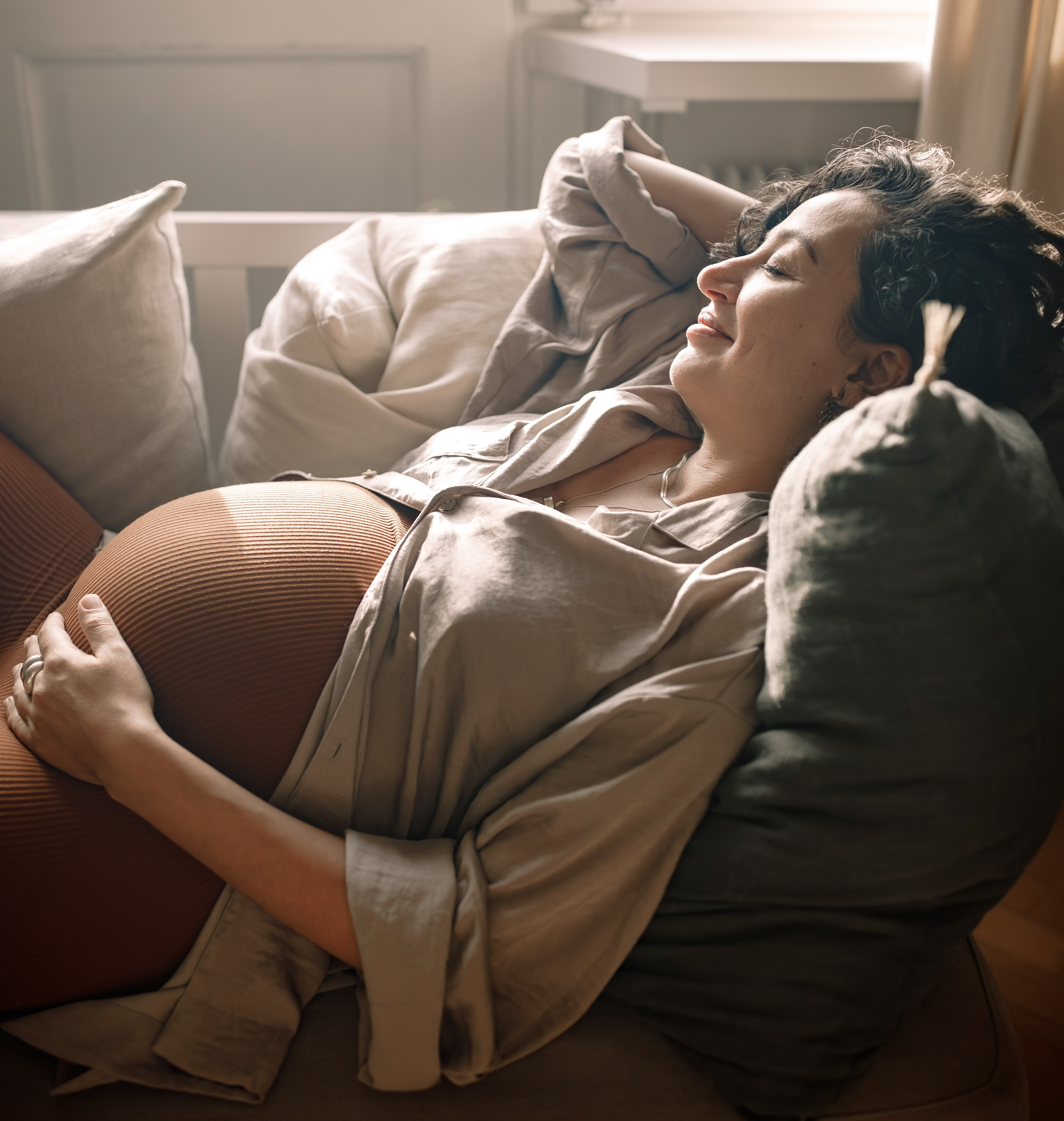 High angle view of pregnant woman relaxing on sofa at home